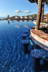 Swim-up bar in infinity pool in tropics