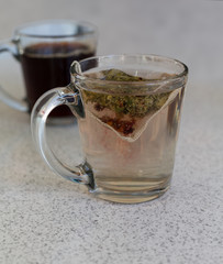 Chamomile teabag in glass mug on table
