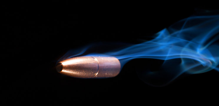 Near miss as seen when a copper bullet is flying by with smoke trailing behind