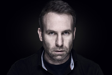 Hutaussehender Mann mit einem düsteren Blick