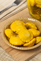 Pickled Yellow Pattypan Squash. Selective focus.