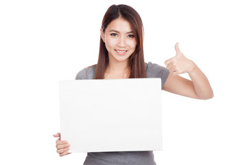 Naklejka premium Young Asian woman thumbs up with blank sign