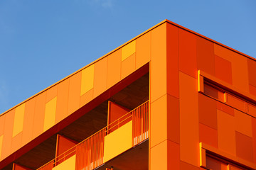 Orange wall and windows of an modern apparment building.