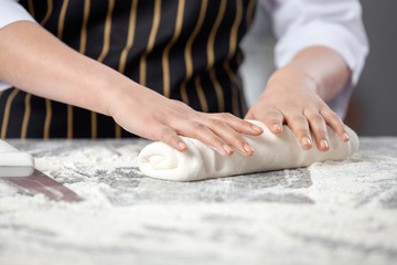 Obraz na płótnie Canvas Female Chef Kneading Dough At Messy Counter