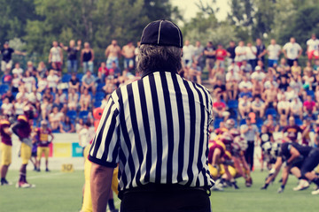 Fototapeta premium American football referee and de-focused players.