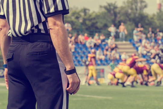 American football referee and de-focused players.