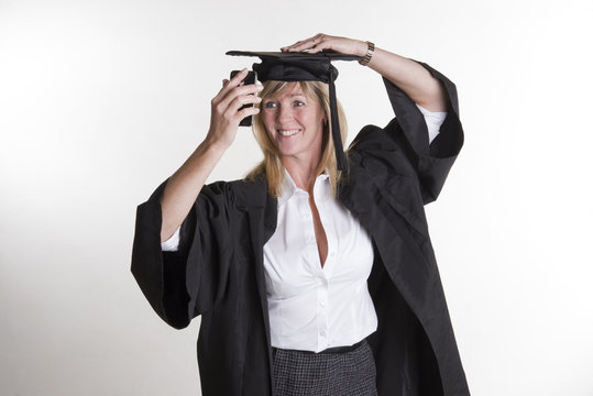 Mature student in cap and gown taking a selfie photo