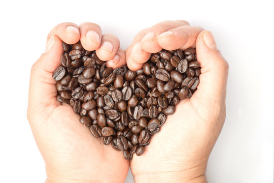 Fresh roasted coffee beans pouring in heart hands