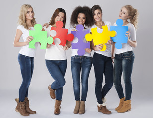 Obraz premium Multi ethnic girls with colored jigsaw puzzle
