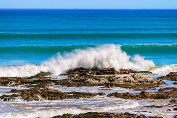 Waves crashing onto the coastal rocks