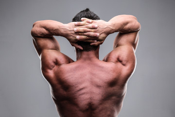 Obraz na płótnie Canvas Rear view of a muscular man over gray background