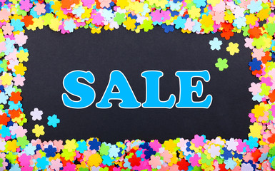Sale word on black background in confetti frame