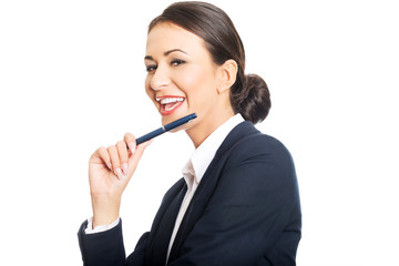 Businesswoman holding pen under chin