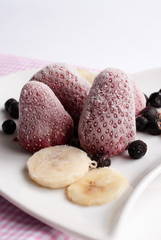 Fresh and cold strawberries, banana slides and blackberries