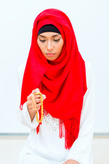 Asian Muslim woman praying with beads chain