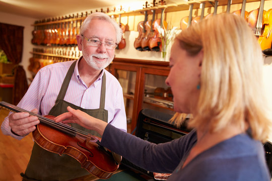 Customer Leaving Violin For Repair In Shop