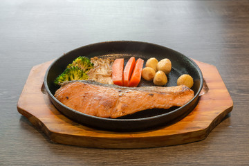 fried salmon steaks on hot pan