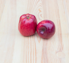 Two red apples on a wooden background