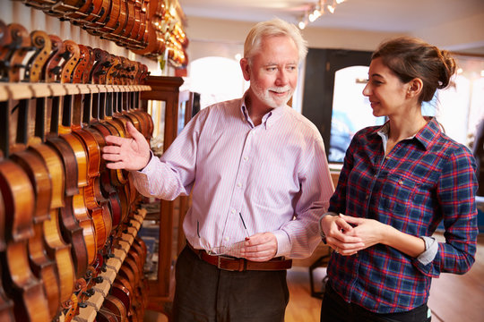 Salesman Advising Customer Buying Violin