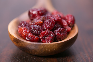dried cranberries in a wooden spoon. fruit full of vitamin c. 