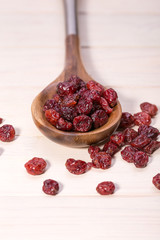dried cranberries in a wooden spoon. fruit full of vitamin c.