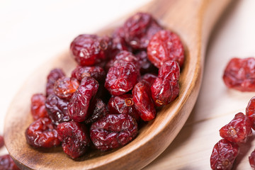 dried cranberries in a wooden spoon. fruit full of vitamin c.