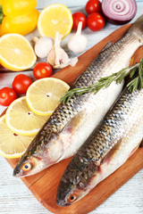 Fresh raw fish and food ingredients on table
