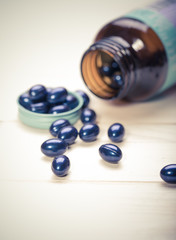 Cod liver oil omega 3 gel capsules isolated on wooden background
