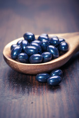 Cod liver oil omega 3 gel capsules isolated on wooden background