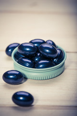 Cod liver oil omega 3 gel capsules isolated on wooden background