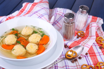 Soup with meatballs and noodles in bowl on wooden background