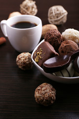 A cup of coffee with chocolates and sweet spoon