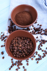 Two bowls of ground coffee and coffee beans