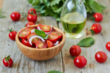 Cherry tomato salad with onion and basil leaves