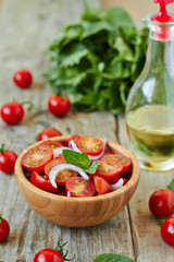 Cherry tomato salad with onion and basil leaves