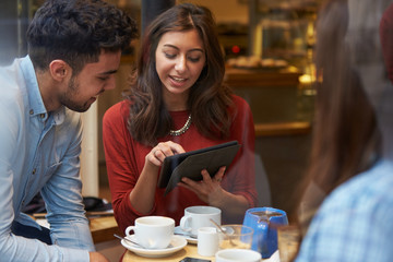 Group Of Friends In Caf‚ Using Digital Tablet