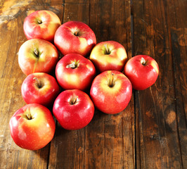 Red apples laid out in triangle on wooden background