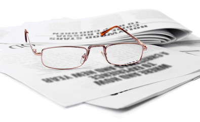Glasses and newspapers, close-up