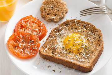 fried egg in a toast and grilled tomatoes for breakfast