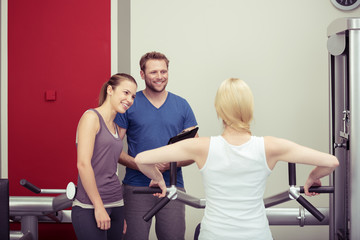 freundlicher trainer berät frauen im fitness-studio