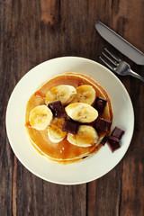 Stack of delicious pancakes with chocolate, honey and slices of