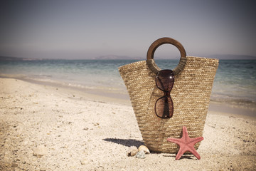 straw bag with sunglasses and starfish