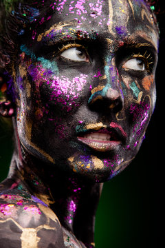 brunette with glowing disco makeup. Black face and neon face art