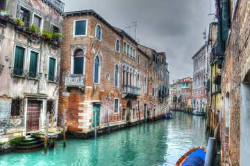 Fototapeta na wymiar Narrow canal in Venice under a gray sky