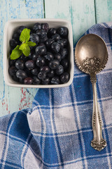 Pot with fresh blueberries mint leaf and silver spoon