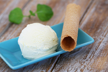 Vanilla ice cream and wafer on rustic wooden surface