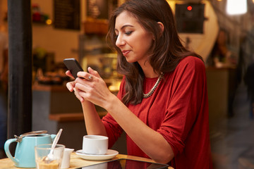 Woman Viewed Through Window Of Caf‚ Using Mobile Phone