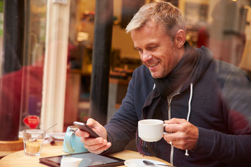Man Viewed Through Window Of Caf‚ Using Mobile Phone