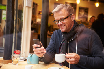 Man Viewed Through Window Of Caf‚ Using Mobile Phone