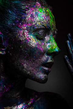 Girl with neon flicker on the face. Black face art and body art.